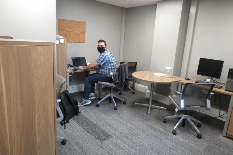 Student working alone in office with mask